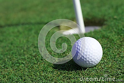 Golfball in front of the hole Stock Photo