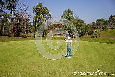 Golfer action happiness winner with long putting golf ball straight to hole Stock Photo