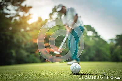 Golfer action to win after long putting golf ball on the green golf Stock Photo