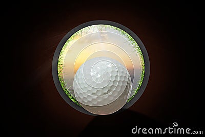 Golfer at golf ball view from inside the hole of cup in the green golf club play and lens flare on sun set evening time gold sky Stock Photo
