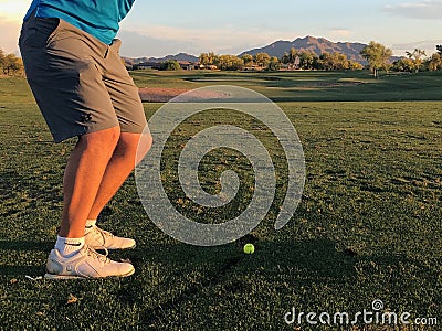 Golfer hitting a golf ball from a back view. Editorial Stock Photo