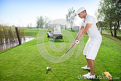 Golfer hitting golf ball Stock Photo