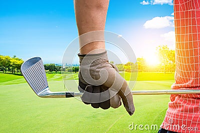 Golfer holding golf club by glove hand to preparing in golf game with sunlight rays Stock Photo