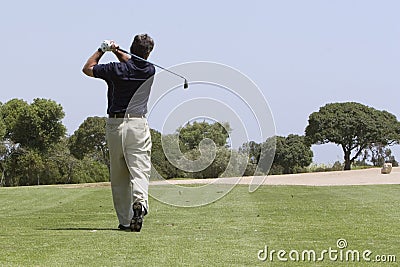 Golfer making fairway shot Stock Photo