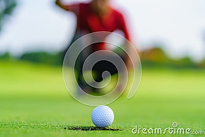 Golfer putt golf ball into hole on the green at golf course Stock Photo
