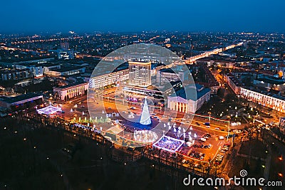 Gomel, Belarus. Main Christmas Tree And Festive Illumination On Lenin Square In Homel. New Year In Belarus. Aerial Night Stock Photo