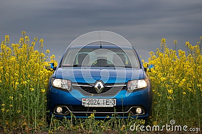 GOMEL, BELARUS - May 24, 2017: the blue car is parked on the rapeseed field. Editorial Stock Photo