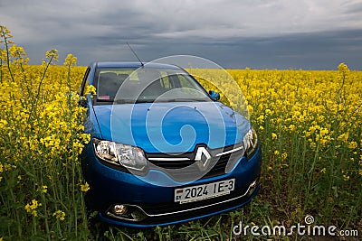 GOMEL, BELARUS - May 24, 2017: the blue car is parked on the rapeseed field. Editorial Stock Photo