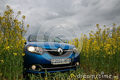 GOMEL, BELARUS - May 24, 2017: the blue car is parked on the rapeseed field. Editorial Stock Photo