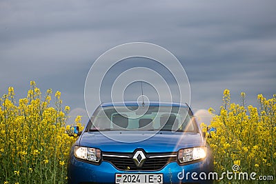 GOMEL, BELARUS - May 24, 2017: the blue car is parked on the rapeseed field. Editorial Stock Photo