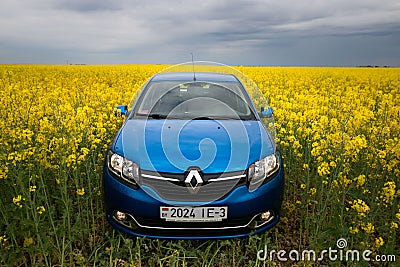 GOMEL, BELARUS - May 24, 2017: the blue car is parked on the rapeseed field. Editorial Stock Photo