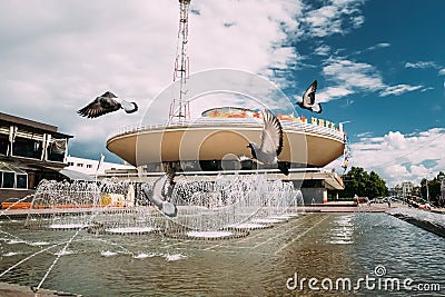 Gomel, Belarus. Pigeons Are Flying Over A Fountain Near Gomel State Circus In A Summer Sunny Day. Editorial Stock Photo