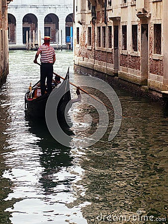 Gondolier ferrying tourists with its gondola in Venice Editorial Stock Photo
