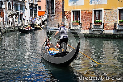 Gondolier navigating a gondola through canal Editorial Stock Photo