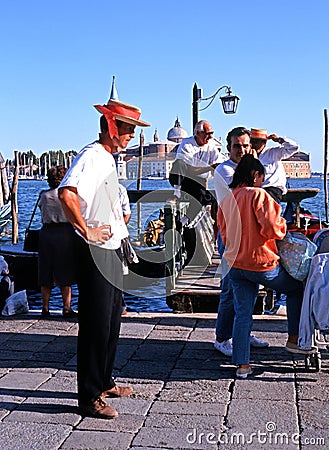 Gondolier on waterfront, Venice. Editorial Stock Photo