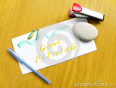 Gone Fishing note on desk Stock Photo