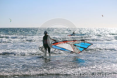 Gone surfing - Girl going windsurfing at the Atlantic ocean Stock Photo