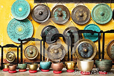 Gongs and singing bowls - traditional Asian musical instruments on a street market. Stock Photo