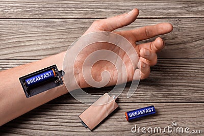Good breakfast energizes all day long. Hand of man with slot for charging batteries with the breakfast Stock Photo
