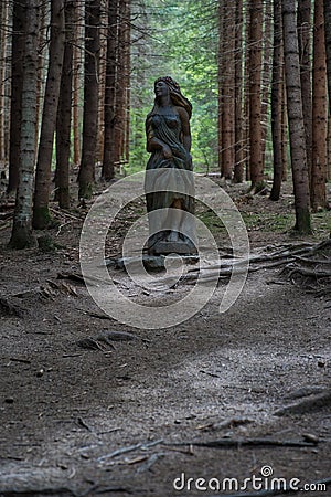 Good forest fairy statue made of wood among the trees Stock Photo