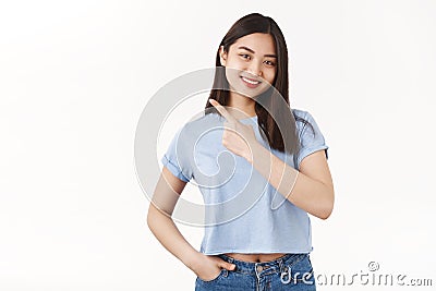 Good-looking friendly outgoing asian brunette female pointing upper left corner assertive smiling broadly give advice Stock Photo