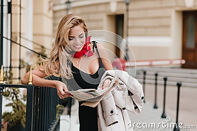 Good-looking laughing woman reading funny joke in newspaper while waiting friend. Outdoor portrait of lovely european Stock Photo