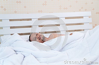 A good looking man sleeps innocently in bed before work. Stock Photo