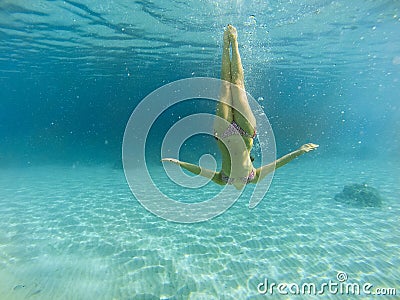 Good looking woman diving under the sea Stock Photo