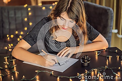 Good morning. Calligrapher Young Woman writes phrase on white paper. Inscribing ornamental decorated letters Stock Photo