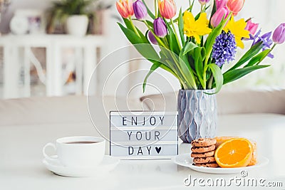 Good morning concept. Romantic breakfast - fresh spring flowers, cup of hot coffee drink, cookies, orange, lightbox with message Stock Photo