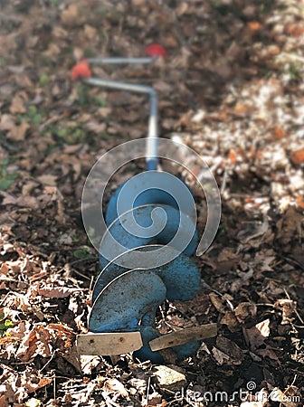 A good oleâ€™ man powered hand held auger laying in the back yard... Stock Photo