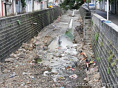 Good Samaritan Responsible Citizen Man clearing drains on Port-Louis Mauritius Editorial Stock Photo
