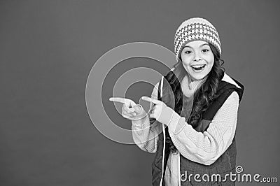 Good stuff that. Happy girl pointing index fingers red background. Small child in winter style pointing at something Stock Photo