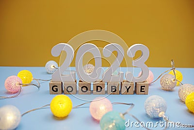 Goodbye 2023 letters with LED cotton balls decoration on blue background Stock Photo