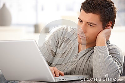 Goodlooking man focusing on laptop Stock Photo