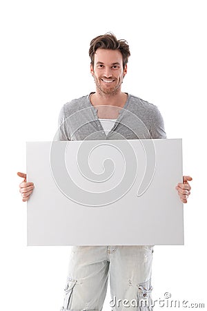 Goodlooking man holding white panel smiling Stock Photo