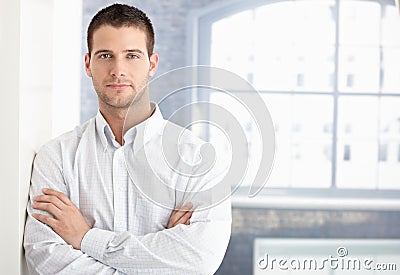 Goodlooking young man standing arms crossed Stock Photo