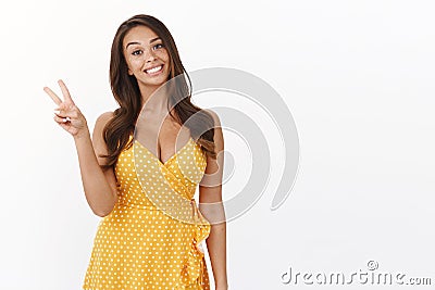 Goodwill, wellbeing and positivity concept. Attractive enthusiastic cute female in yellow summer dress, dress-up date Stock Photo