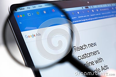 Google Ads logo enlarged through a magnifying glass on a laptop screen Editorial Stock Photo