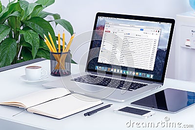 Google Gmail interface on Apple MacBook screen on office desk Editorial Stock Photo