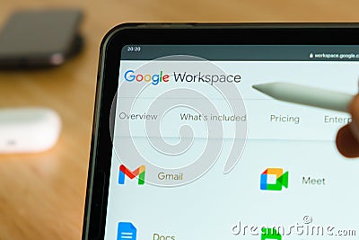 Google Workspace logo shown by apple pencil on the iPad Pro tablet screen. Man using application on the tablet. December Editorial Stock Photo