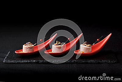 Goose liver pate, foie gras, served on black stone in Japanese red spoons. Paste served with jam and nuts. Fusion food Stock Photo