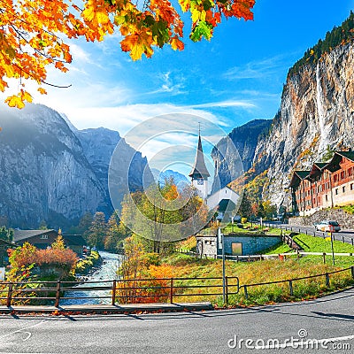 Gorgeous autumn landscape of alpine village Lauterbrunnen with famous church and Staubbach waterfall Stock Photo