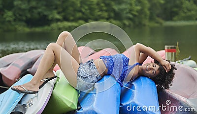 Prety biracial woman poses on canoes Stock Photo