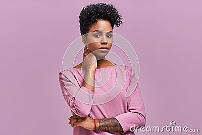 Gorgeous dark skinned young female with Afro hairstyle and confident look, poses for fashionable magazine, looks aside Stock Photo