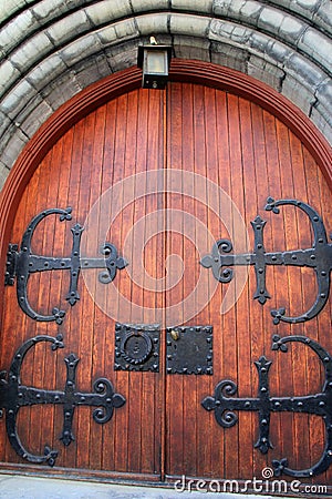 Gorgeous detail in heavy wood doors with elaborate black,metal hardware Stock Photo