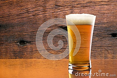 Gorgeous glass of delicious beer with barn wood background Stock Photo