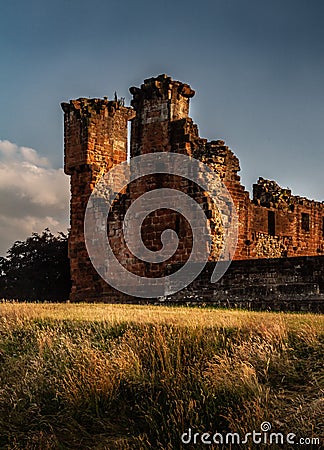Gorgeous moody shot of the corner portion and surrounding wall of Penrith Castle at sunset in Cumbria, England Stock Photo