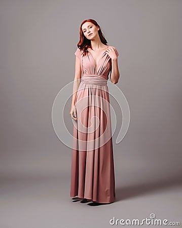 Gorgeous salmon transformer dress. Beautiful sexy silk evening gown with deep neckline and shoulder straps. Stock Photo