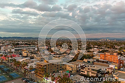 A gorgeous shot of the buildings in the cityscape near the beach at sunset with powerful red clouds, blue sky and mountain ranges Editorial Stock Photo